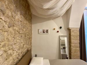科拉托Altrelli B&B的一间卧室设有石墙、一张床和镜子