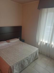 拉奎拉Hotel Porta Rivera Plesso Stazione的一间卧室设有一张床和一个窗口