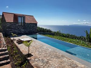 加乌拉CASAS DO LARANJO- Cottages & Infinity Pool的海边带游泳池的房子