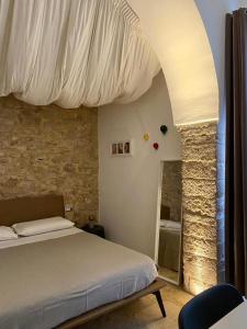 科拉托Altrelli B&B的一间卧室设有一张床和石墙
