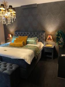 布鲁日't Hartje van Brugge的一间卧室配有一张带蓝色床头板的床和两盏灯。