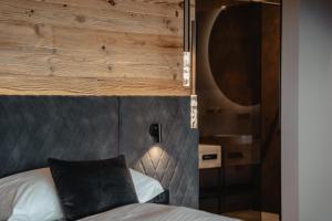 卡雷扎湖Hotel Alpenrose的一间卧室配有一张木墙床