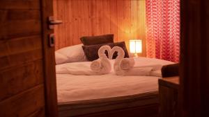 新里斯拉Vila Somani的卧室配有一张床上的2条天鹅形毛巾