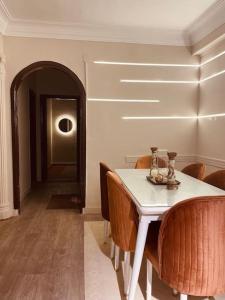 开罗lovely apartment in Zamalek的一间配备有白色桌椅的用餐室