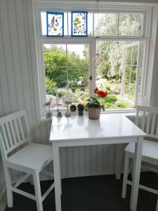 科特卡Guesthouse Lokinlaulu的窗前的一张白色桌子和两把椅子