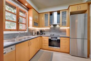 约阿尼纳Harmony villa - Ioannina castle的厨房配有木制橱柜和不锈钢冰箱。