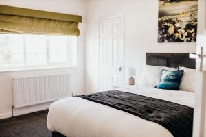 林肯Hideaway by Liv Retreats的一间卧室设有一张大床和一个窗户。