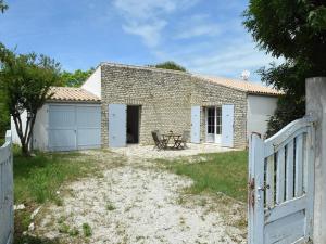 莱斯波特斯Maison cosy près du centre des Portes-en-Ré, 2 chambres, forfait ménage inclus - FR-1-434-73的砖屋,带桌子和围栏