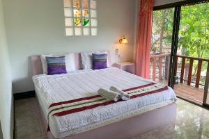 湄宏颂普桥姆延度假村的带阳台的卧室内的一张大床