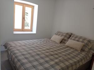 耶尔萨Heritage 4-star Studio Apartment Pitve Hvar的一张带铺着地毯的床和一个窗户