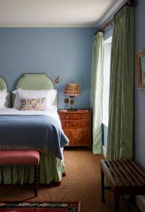 马基特德雷顿The Bear Inn, Hodnet的蓝色的卧室设有床和窗户