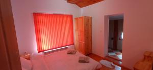 瑟尔尼察Къща за гости Джамбазови的一间设有床铺和红色窗户的客房