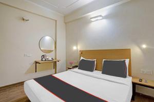 IndirapuramCapital O Mt Corporate Stays Near Iskcon Temple Noida的一间卧室配有一张大床和镜子