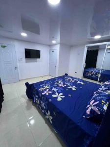 圣地亚哥洛斯卡巴Alojamiento paulino的一间卧室配有一张带鲜花的蓝色床