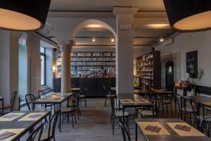 曼托瓦Ca' Tazzoli的一间带桌椅的餐厅和一间酒吧