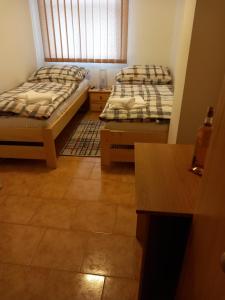 博耶蒂采Penzion Bernardýn的一间带两张床的卧室,铺有瓷砖地板
