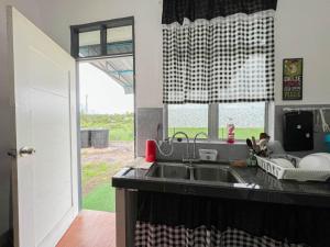 丹那美拉COZY HOMESTAY的厨房设有水槽和窗户。