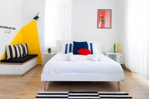 耶路撒冷Mamilla View- Suites & Apt Hotel的卧室配有白色的床和色彩缤纷的枕头