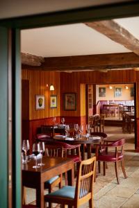 马基特德雷顿The Bear Inn, Hodnet的餐厅拥有木墙和桌椅