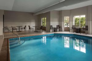 奥兰帕克希尔顿奥兰多帕克霍姆伍德套房酒店的酒店客房的游泳池配有桌椅