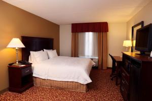 夏洛茨维尔夏洛特维尔大学希尔顿恒庭旅馆&套房酒店的配有一张床和一台平面电视的酒店客房