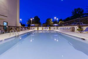 夏洛茨维尔夏洛茨维尔汉普顿酒店的夜间游泳池,灯光照亮酒店
