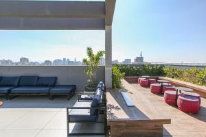 圣保罗MOL - Liberdade - Anora Spaces Residenciais的屋顶上带沙发和桌子的庭院