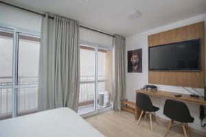 圣保罗MOL - Liberdade - Anora Spaces Residenciais的酒店客房配有一张床和一张书桌及一台电视