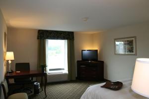 门托克利夫兰门托希尔顿恒庭旅馆&套房酒店的配有一张床、一张书桌和一扇窗户的酒店客房