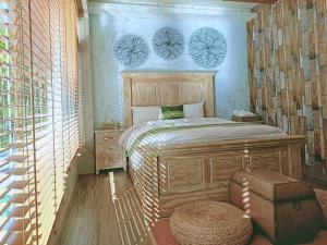 鱼池乡散步的云-日月潭生态民宿的一间卧室配有一张床和一张搁脚凳