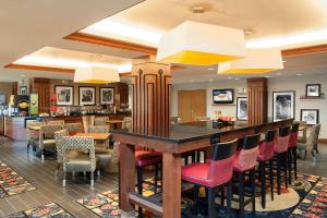 爱丁堡哥伦布/泰勒斯维尔希尔顿恒庭酒店的餐厅设有红色椅子和酒吧