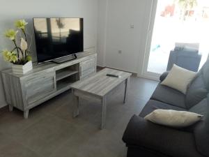 阿利坎特Villa María的客厅配有电视、沙发和桌子