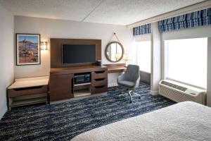 康梅克康马克/长岛希尔顿恒庭酒店的酒店客房配有一张床、一台电视和一把椅子