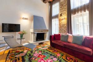 卡内利Relais Villa del Borgo的客厅设有红色的沙发和壁炉