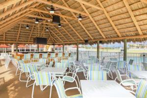 代托纳海滩代托纳海滩/海滨汉普顿酒店的一组桌子和椅子,位于木屋顶下