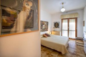 萨萨里Villa Brandinu的卧室配有一张床,墙上挂有绘画作品