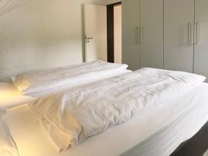 锡默拉特Ferienpark Rursee的床上铺有白色床单