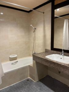 拉迈夏日酒店的浴室配有盥洗盆、浴缸和镜子