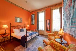 萨克拉门托你好萨克拉门托青年旅舍的一间卧室拥有橙色的墙壁,配有一张床和一张沙发