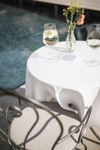 拉古多Residence Hirzer的一张带酒杯和鲜花的白色桌子