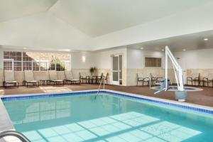 法戈法戈希尔顿惠庭套房酒店的游泳池位于酒店客房内,配有桌椅