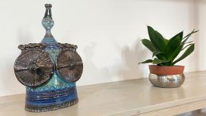 卡拉赛达I tre schen的坐在盆栽旁边桌子上的蓝色花瓶