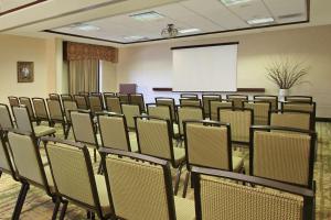 弗洛伦斯佛罗伦萨市区汉普顿套房酒店的一间会议室,配有椅子和白色屏幕