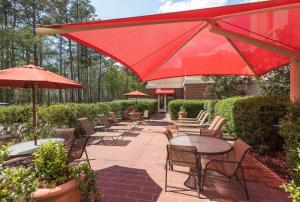 佛罗伦萨Hampton Inn & Suites Florence-North-I-95的一个带桌椅和遮阳伞的庭院