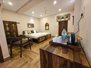 焦特布尔Khamma Heritage的酒店客房,配有床和桌子,并提供一瓶水