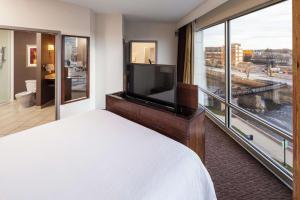苏福尔斯苏福尔斯市中心希尔顿花园酒店的酒店客房设有一张床和一个大窗户