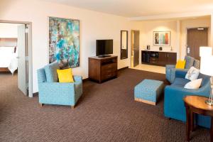 苏福尔斯苏福尔斯市中心希尔顿花园酒店的客厅配有2把蓝色椅子和电视