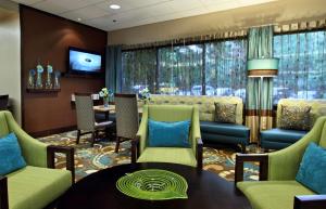 黑格斯敦黑格斯敦希尔顿恒庭酒店的一间设有绿色椅子和桌子的等候室