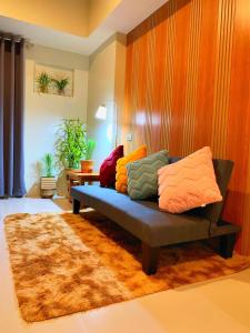 碧瑶Cozynest Condotel Baguio的客厅里一张长沙发,上面有色彩缤纷的枕头