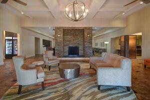 休斯顿休士顿乔治布希洲际机场希尔顿惠庭套房酒店的客厅配有沙发、椅子和壁炉